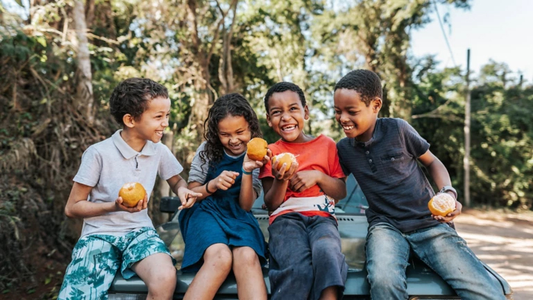 Photo of children eating fruit and laughing